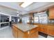 Kitchen features an island, tile floors, and wood cabinets with views to an adjoining dining area at 6578 Chimes Tower Ave, Las Vegas, NV 89139