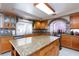 Well-lit kitchen features oak cabinets, tile backsplash, stainless steel appliances and granite-topped center island at 6578 Chimes Tower Ave, Las Vegas, NV 89139