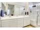 Bright bathroom with double sinks, a large mirror, and a tiled walk-in shower at 762 Lilac Oak St, Henderson, NV 89011