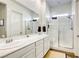 Bathroom featuring double sinks, a large mirror, and a modern walk-in shower at 762 Lilac Oak St, Henderson, NV 89011
