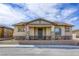 Charming single-story home featuring a covered front porch with stone accents and a well-manicured lawn at 762 Lilac Oak St, Henderson, NV 89011