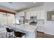Well-lit kitchen with stainless steel appliances, an island with seating, and sliding doors to the patio at 762 Lilac Oak St, Henderson, NV 89011