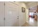 Welcoming home hallway with neutral walls, tiled flooring, and a view into the cozy living area at 7824 Homing Pigeon St, North Las Vegas, NV 89084