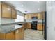 Efficient kitchen boasts wood cabinets, laminate counters, and modern black appliances at 8646 Mesquite Hills St, Las Vegas, NV 89139