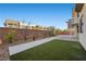 This backyard has a strip of artificial turf, a walkway, a brick wall, and fresh landscaping at 88 Pristine Glen St, Las Vegas, NV 89135
