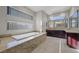 Bright bathroom features a modern soaking tub with a stone surround and large vanity mirror at 88 Pristine Glen St, Las Vegas, NV 89135