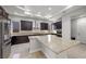 Spacious kitchen featuring a large island with granite countertops, dark wood cabinets, and stainless steel appliances at 88 Pristine Glen St, Las Vegas, NV 89135