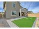 This backyard features a small lawn, a brick perimeter and a concrete paver patio at 8866 Mountain Lion Ave, Las Vegas, NV 89166