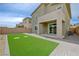 Spacious backyard featuring synthetic grass, a covered patio, and a brick-paved area, perfect for outdoor living at 8866 Mountain Lion Ave, Las Vegas, NV 89166