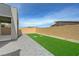 This backyard features a small lawn, a brick perimeter and a concrete paver patio at 8866 Mountain Lion Ave, Las Vegas, NV 89166