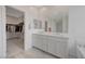 Bathroom showcasing dual vanities, tile flooring, walk-in shower and large mirror at 8866 Mountain Lion Ave, Las Vegas, NV 89166
