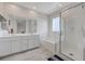 Elegant bathroom featuring dual vanities, soaking tub, walk-in shower with glass door, and tile flooring at 8866 Mountain Lion Ave, Las Vegas, NV 89166