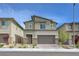 Two-story home featuring a two-car garage, desert landscaping, and modern architectural details at 8866 Mountain Lion Ave, Las Vegas, NV 89166