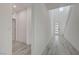 Bright hallway featuring wood-look floors, leading to a modern front door and staircase with white walls at 8866 Mountain Lion Ave, Las Vegas, NV 89166