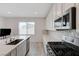 Galley kitchen with stainless appliances, ample white cabinets, and mosaic tile backsplash at 8866 Mountain Lion Ave, Las Vegas, NV 89166
