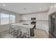 Modern kitchen with white cabinetry, quartz countertops, stainless steel appliances, and a large island with seating at 8866 Mountain Lion Ave, Las Vegas, NV 89166