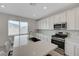 Bright kitchen featuring white cabinets, stainless steel appliances, and a large island with bar stool seating at 8866 Mountain Lion Ave, Las Vegas, NV 89166