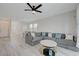 Spacious living room with gray sectional sofa, white tile floors, and ample natural light at 8866 Mountain Lion Ave, Las Vegas, NV 89166