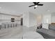 Bright open-concept living space with kitchen island, gray sofa, and white tile flooring at 8866 Mountain Lion Ave, Las Vegas, NV 89166