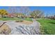 A beautiful park featuring lush green grass, mature trees, a playground, covered picnic area, and paved walking paths at 8868 Intertwine, Las Vegas, NV 89149