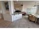 Bright kitchen and dining area showcasing tile floors, granite countertops, and essential appliances at 9126 Haddington Ln, Las Vegas, NV 89145