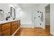 Modern bathroom with dual vanity, soaking tub, glass shower, and wood floors at 9741 Horizon Hills Dr, Las Vegas, NV 89117