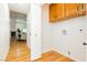Laundry room with wood floors and cabinets with view into dining room at 9741 Horizon Hills Dr, Las Vegas, NV 89117