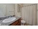Clean bathroom featuring a granite countertop vanity, toilet, and shower with a white curtain at 980 Aspen Cliff Dr, Henderson, NV 89011
