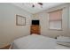 Bright bedroom with a wooden dresser, a television, and a bed with striped bedding at 980 Aspen Cliff Dr, Henderson, NV 89011