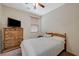 Inviting bedroom with a wooden dresser and a bed with striped bedding under a ceiling fan at 980 Aspen Cliff Dr, Henderson, NV 89011