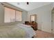 Bright bedroom with a large window, wooden furniture, and neutral carpet flooring at 980 Aspen Cliff Dr, Henderson, NV 89011