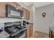 View of a Whirlpool gas range and microwave in a kitchen with wood cabinets at 980 Aspen Cliff Dr, Henderson, NV 89011