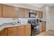 A full kitchen with gas range, built-in microwave, and beautiful wood cabinets at 980 Aspen Cliff Dr, Henderson, NV 89011