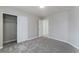A bright bedroom with neutral walls and gray carpet features a closet and entry doors at 7940 Violet Dawn St, Las Vegas, NV 89149