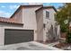 Tan two-story home with a two car garage, red tile roof, and minimal landscaping at 7940 Violet Dawn St, Las Vegas, NV 89149