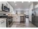 Well-equipped kitchen with stainless steel appliances, white cabinets, and a view to the living room at , Las Vegas, NV 89149