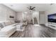 Bright living room featuring a sectional sofa, sleek flooring, and staircase access at 7940 Violet Dawn St, Las Vegas, NV 89149