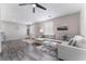 Spacious living area with a large sectional, dining table, and modern ceiling fan at 7940 Violet Dawn St, Las Vegas, NV 89149
