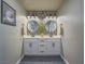 Elegant bathroom with dual sinks, round mirrors, stylish light fixtures, and modern tile backsplash at 10768 Ditchburn Ct, Las Vegas, NV 89166