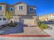 Inviting townhouse featuring a two-car garage, brick-paved driveway, and neatly arranged front yard landscaping at 10768 Ditchburn Ct, Las Vegas, NV 89166