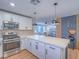 Open kitchen with stainless steel appliances, white countertops, and view to the living room at 10768 Ditchburn Ct, Las Vegas, NV 89166