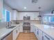 Modern kitchen featuring stainless steel appliances, white cabinets, and a view into the living area at 10768 Ditchburn Ct, Las Vegas, NV 89166