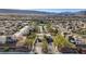 Expansive aerial view of the Trilogy community with lush landscaping, mountains in the background, and a refreshing pool area at 10985 Limeslice Ave # 2, Las Vegas, NV 89135