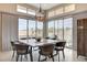 Elegant dining area with modern lighting fixture, large windows, and seating for eight at 10985 Limeslice Ave # 2, Las Vegas, NV 89135