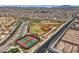 Wide aerial shot showcasing community recreational facilities like tennis and baseball fields near residential homes at 117 Blue Trout Ave, Henderson, NV 89011