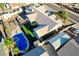 Property featuring a pool, green turf, shade awnings, and multiple storage buildings at 1630 Sundown Dr, Henderson, NV 89002