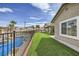 Backyard with artificial grass, swimming pool, privacy fence, and mature palm trees at 1630 Sundown Dr, Henderson, NV 89002