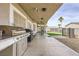 Backyard patio area with outdoor seating, built in grill and lush landscaping at 1630 Sundown Dr, Henderson, NV 89002