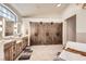 Spacious bathroom featuring double vanities, soaking tub, and rustic barn door closet at 1630 Sundown Dr, Henderson, NV 89002