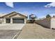 House exterior features a three-car garage and expansive gravel parking area for RV at 1630 Sundown Dr, Henderson, NV 89002